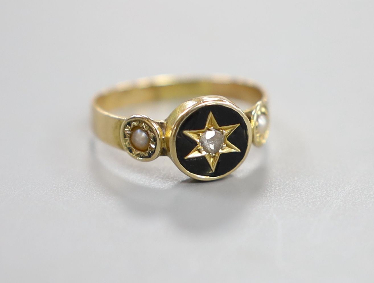 A Victorian yellow metal black enamel, seed pearl and diamond set mourning ring, size O/P, gross weight 2.3 grams.